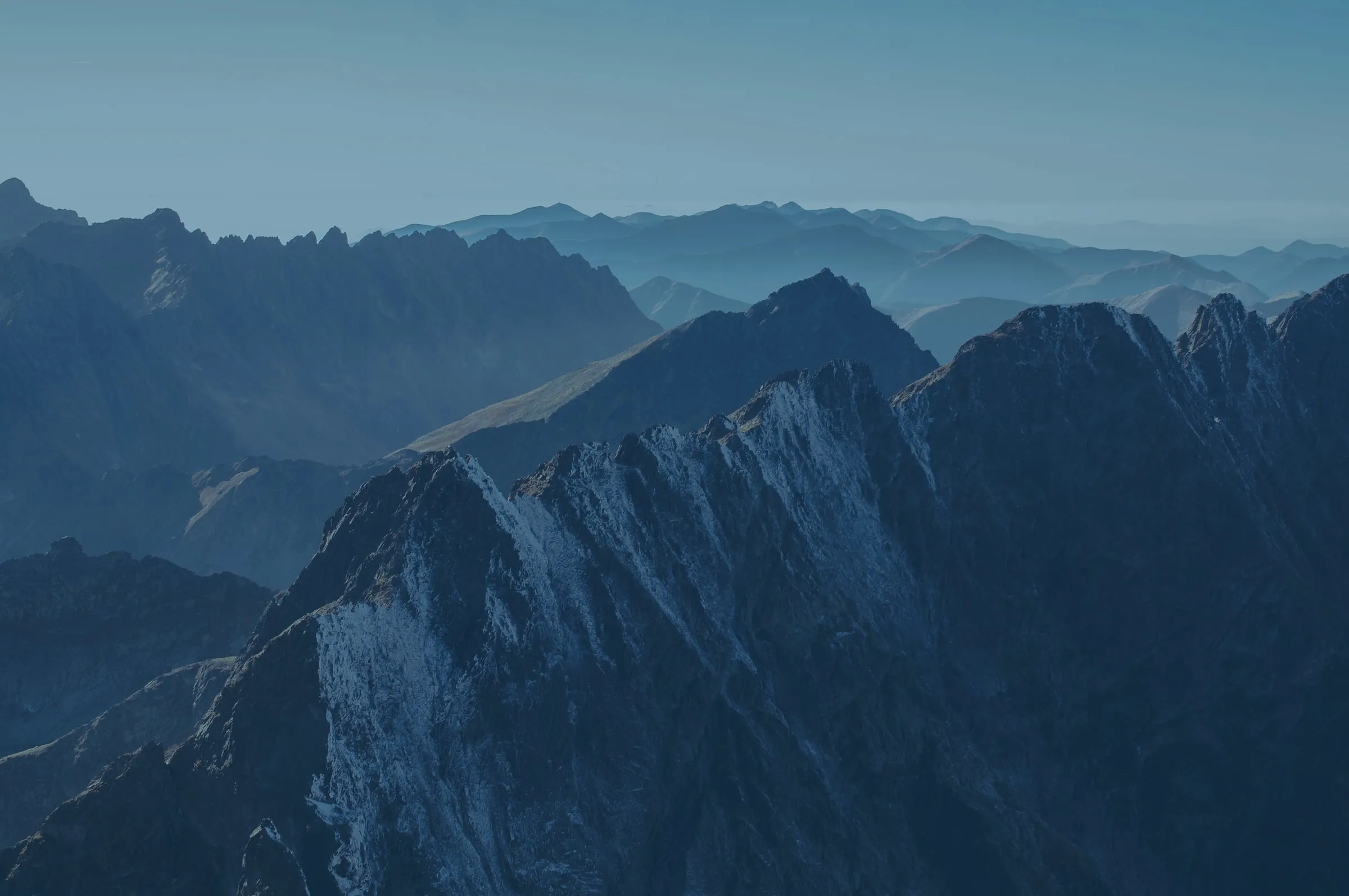 Jagged mountain ridges fading into haze, from Aimplan's website